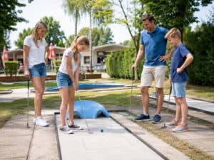 Familie spielt auf normaler Minigolfbahn